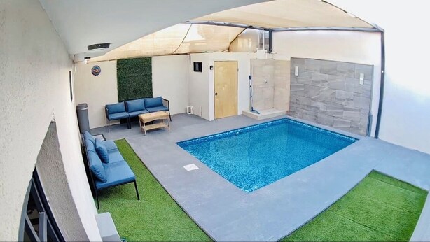 Une piscine extérieure couverte, dotée d’un espace détente et d’une porte.