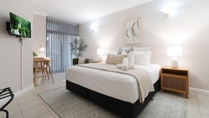 A modern bedroom with a large bed, bedside tables, a desk, and a TV. - Convenient CBD Location, Pool/Gym + walk to shops (Darwin)