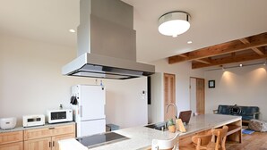Una cucina moderna con isola centrale, elettrodomestici integrati e pavimento in legno.