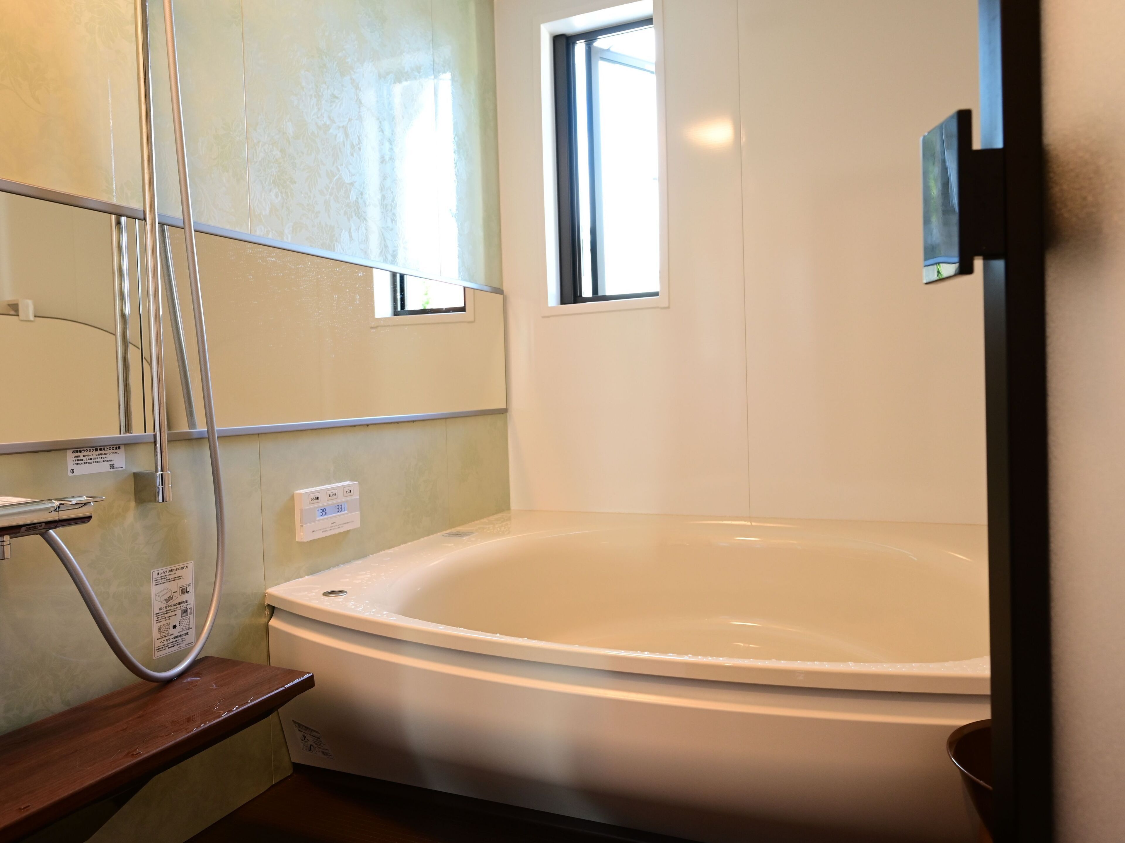 Ein Badezimmer mit Badewanne, Dusche und Fenster.