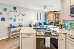 A kitchen with a stove, oven, and a dining area with a table and chairs.
