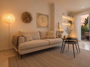 A modern living room with a sofa, a round coffee table, a floor lamp, and a decorative wall piece.