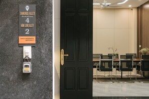 L'ingresso di una camera d'albergo con una porta nera, una serratura a tastierino numerico e una targa che indica il numero 4, via Ham Long Alley, 2.