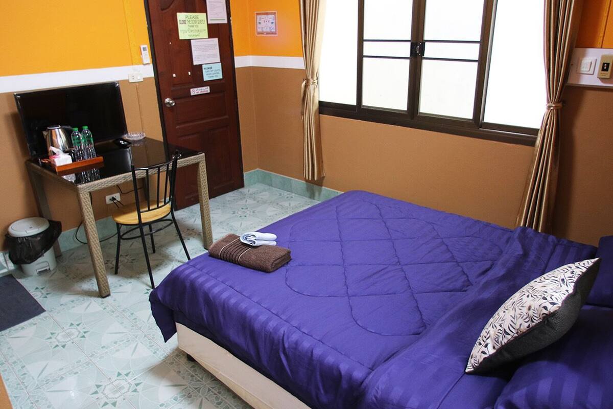 Una habitación con una cama, un escritorio y una silla.
