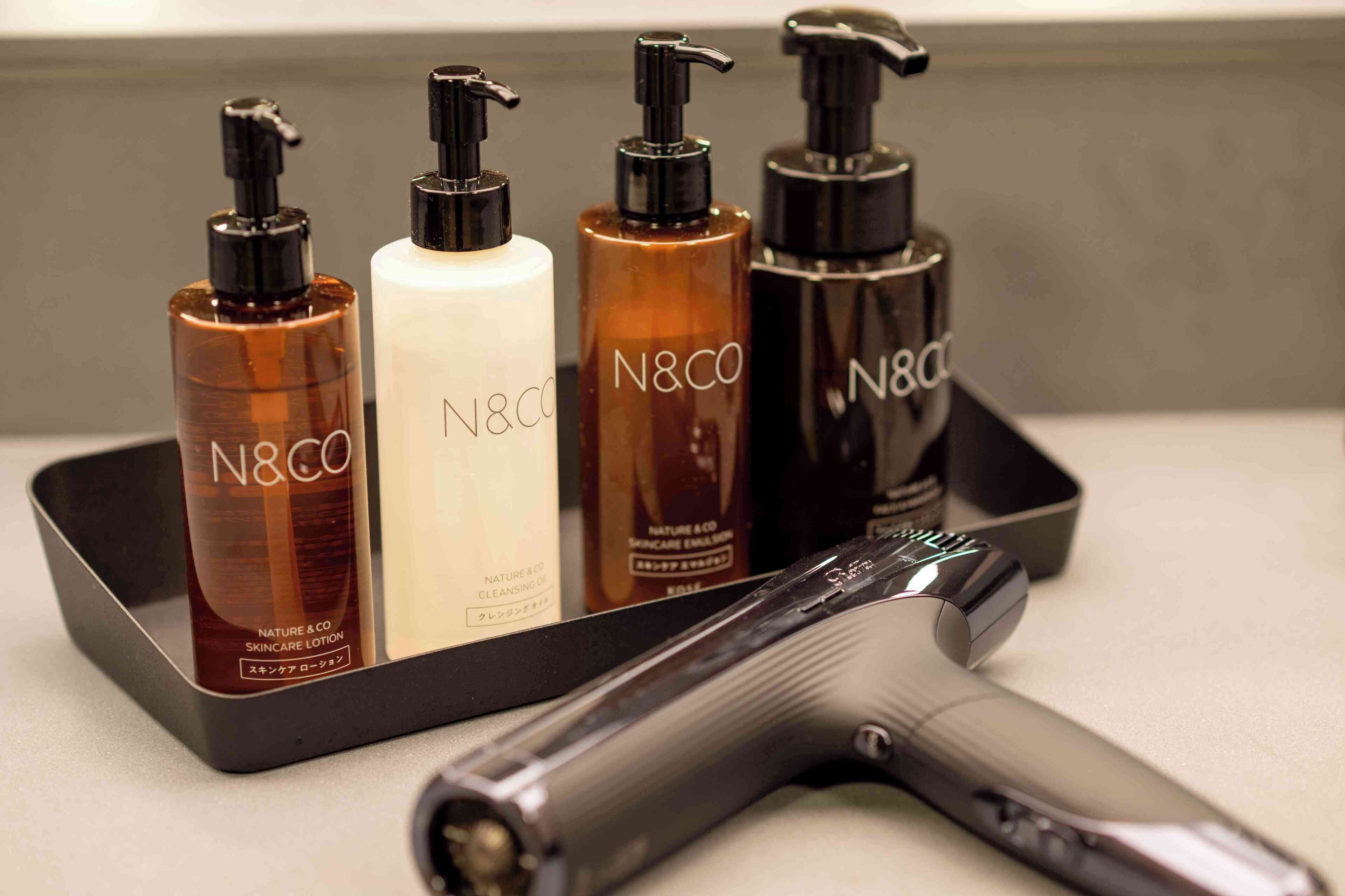 A set of N&CO skincare products on a tray with a hairdryer.