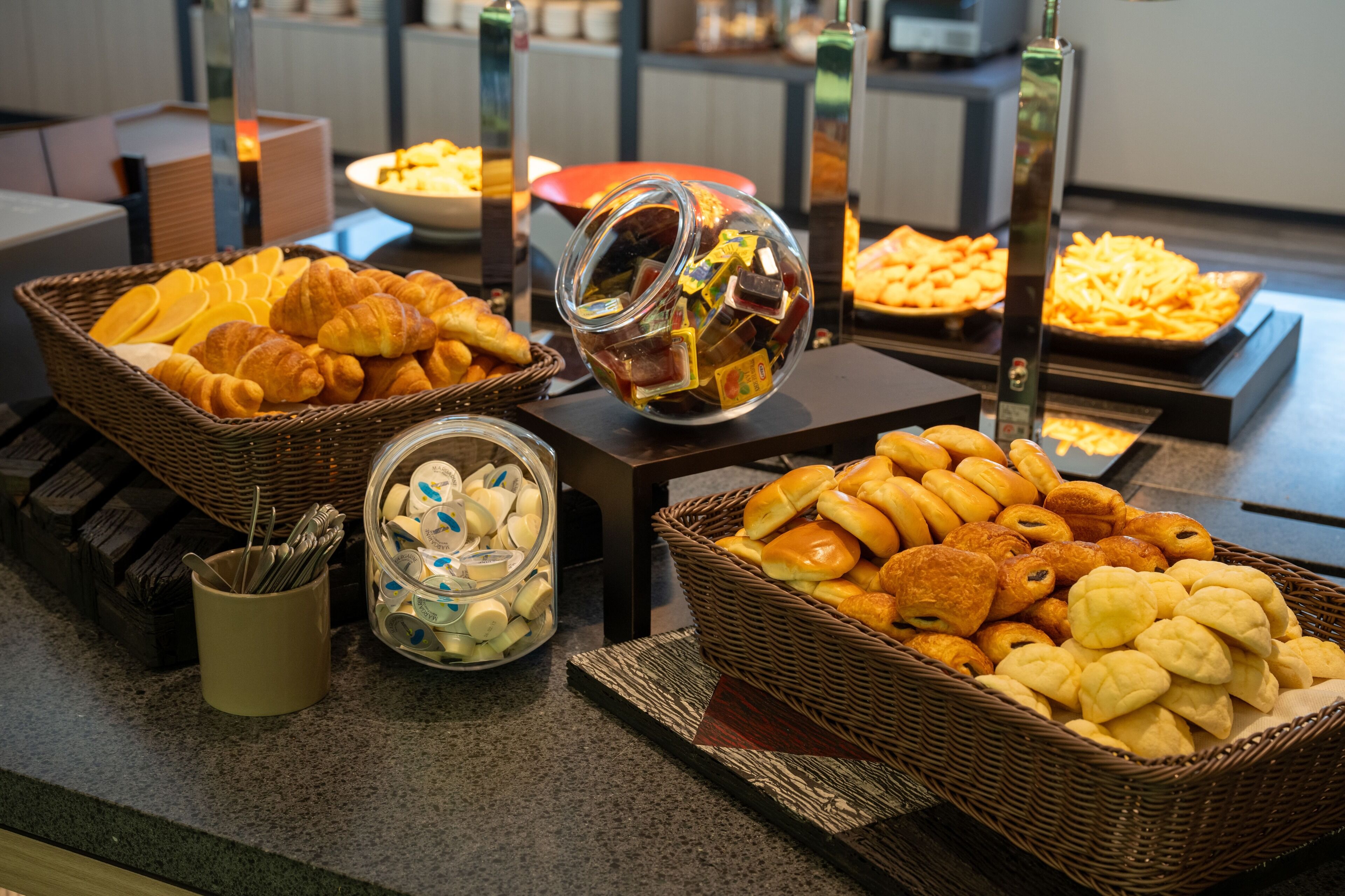 A buffet with various baked goods and pastries.
