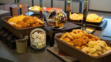 A buffet with various baked goods and pastries.
