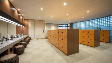 A modern bathroom with multiple sinks, wooden lockers, and a checkered floor.