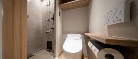 A modern bathroom with a shower, toilet, and a wooden shelf.