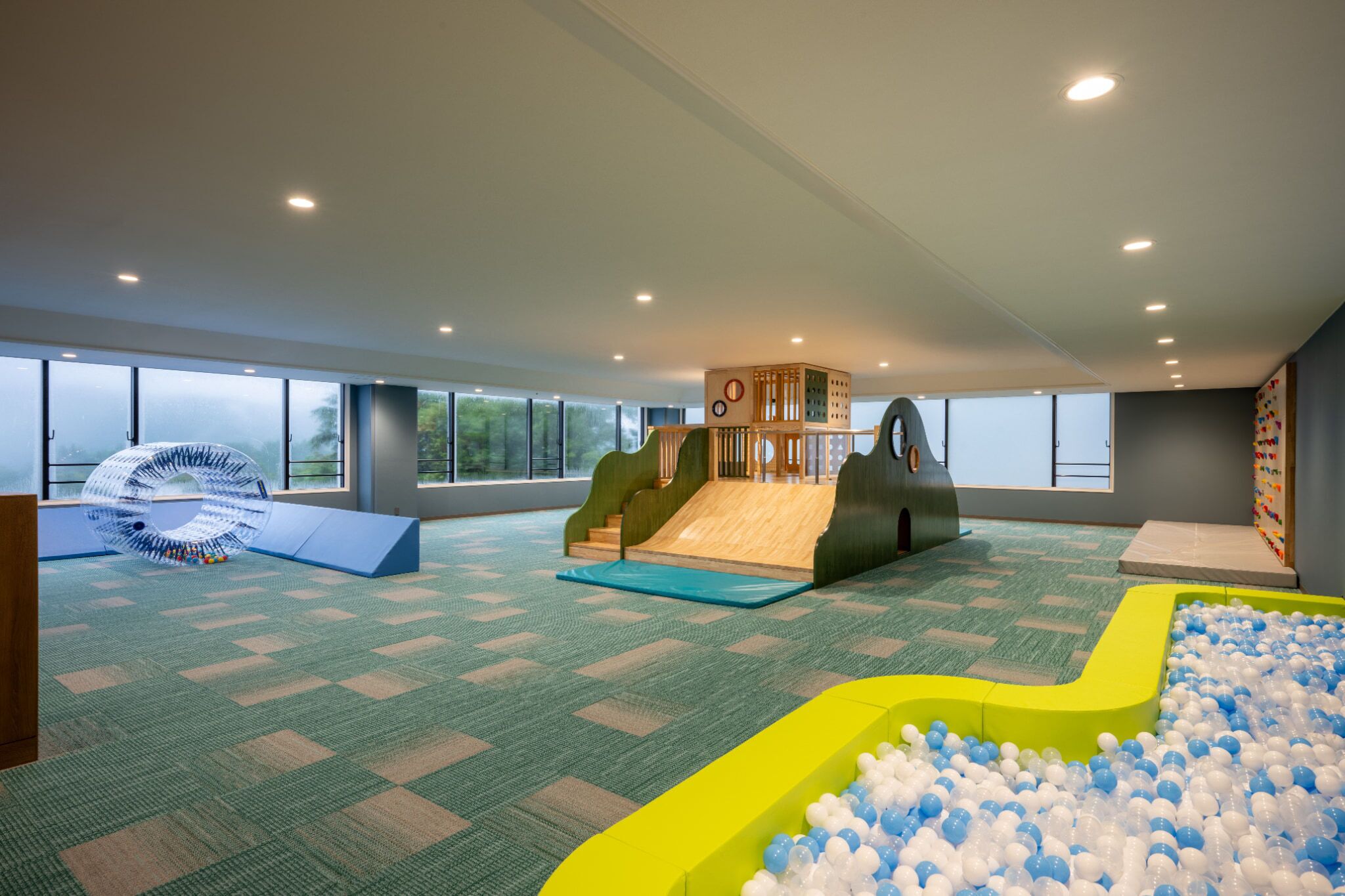 A spacious indoor play area with a slide, ball pit, and climbing structures.