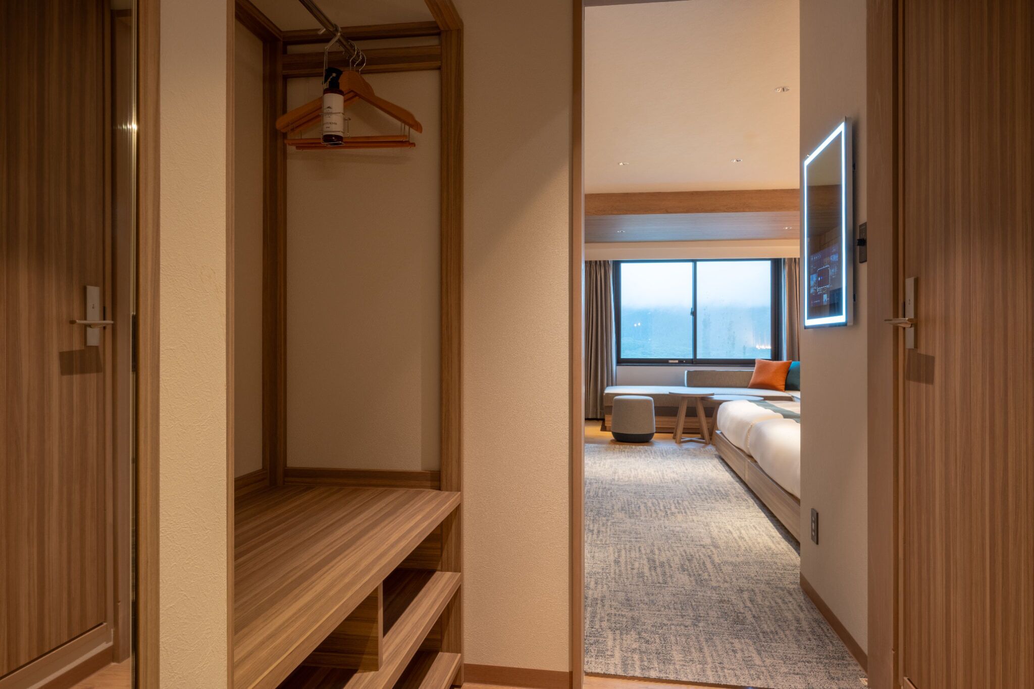A hotel room with a large bed, a desk, and a view of the city.