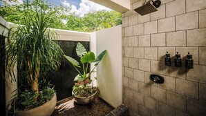 A modern shower with a rain showerhead, a potted plant, and a wall-mounted soap dispenser. - Villa del BroDor Amor, beautiful home with access to 2 beaches Tamarindo and Langosta (Playa Langosta)
