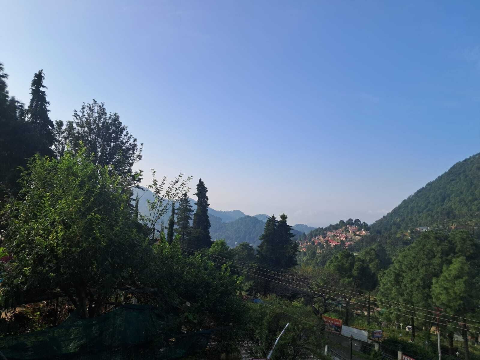 A mountainous landscape with dense greenery and a clear sky.