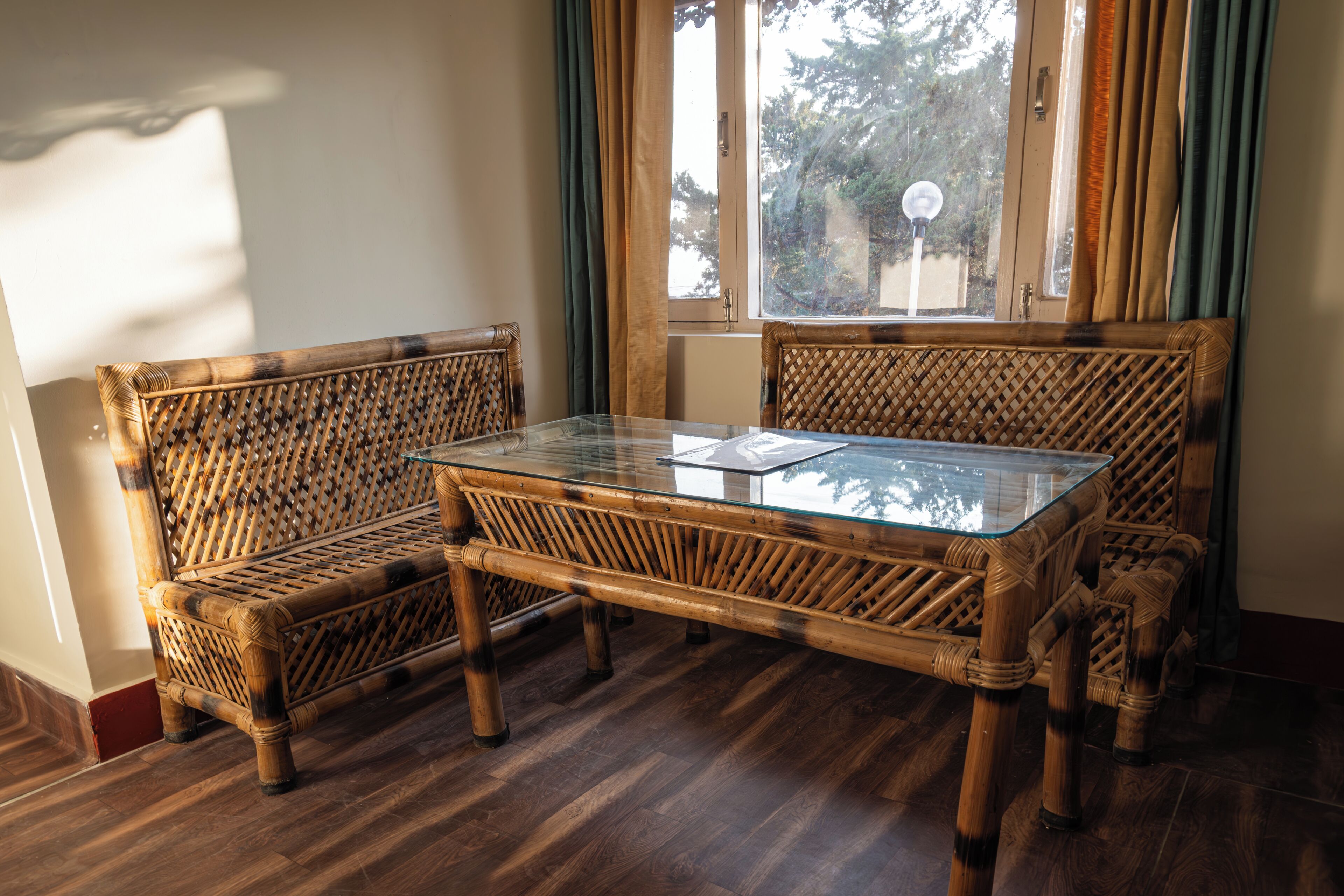 Une pièce avec une table à plateau en verre et deux chaises en osier.