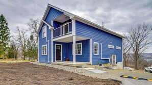 Une maison à deux étages avec un balcon, un garage et une allée.