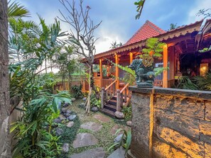 A tropical resort with a wooden structure, a stone pathway, and lush greenery. - Edge of Ubud by GenuineHost (Ubud)