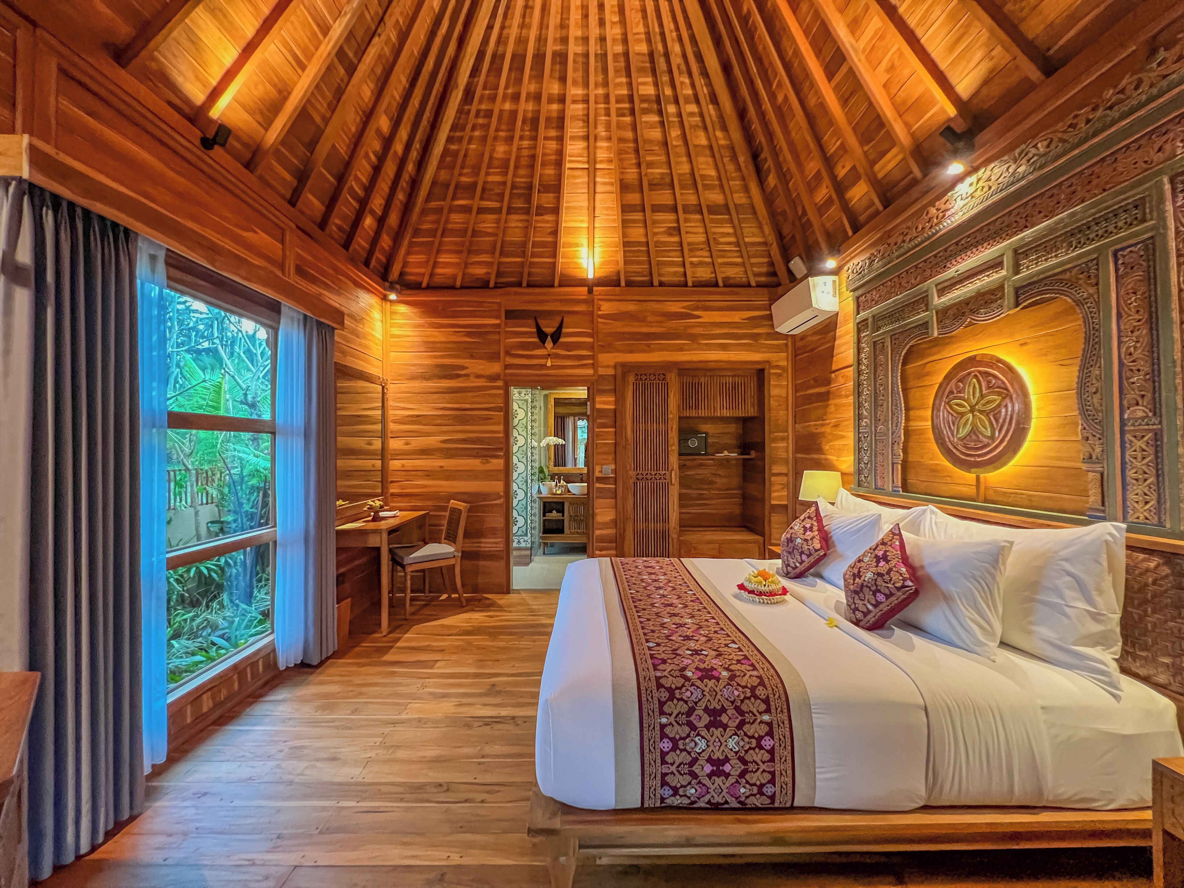 Una habitación de madera con cama, escritorio y ventana.