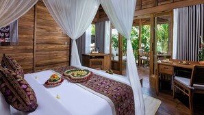 A room with a bed, a desk, and a view of greenery. - Edge of Ubud by GenuineHost (Ubud)
