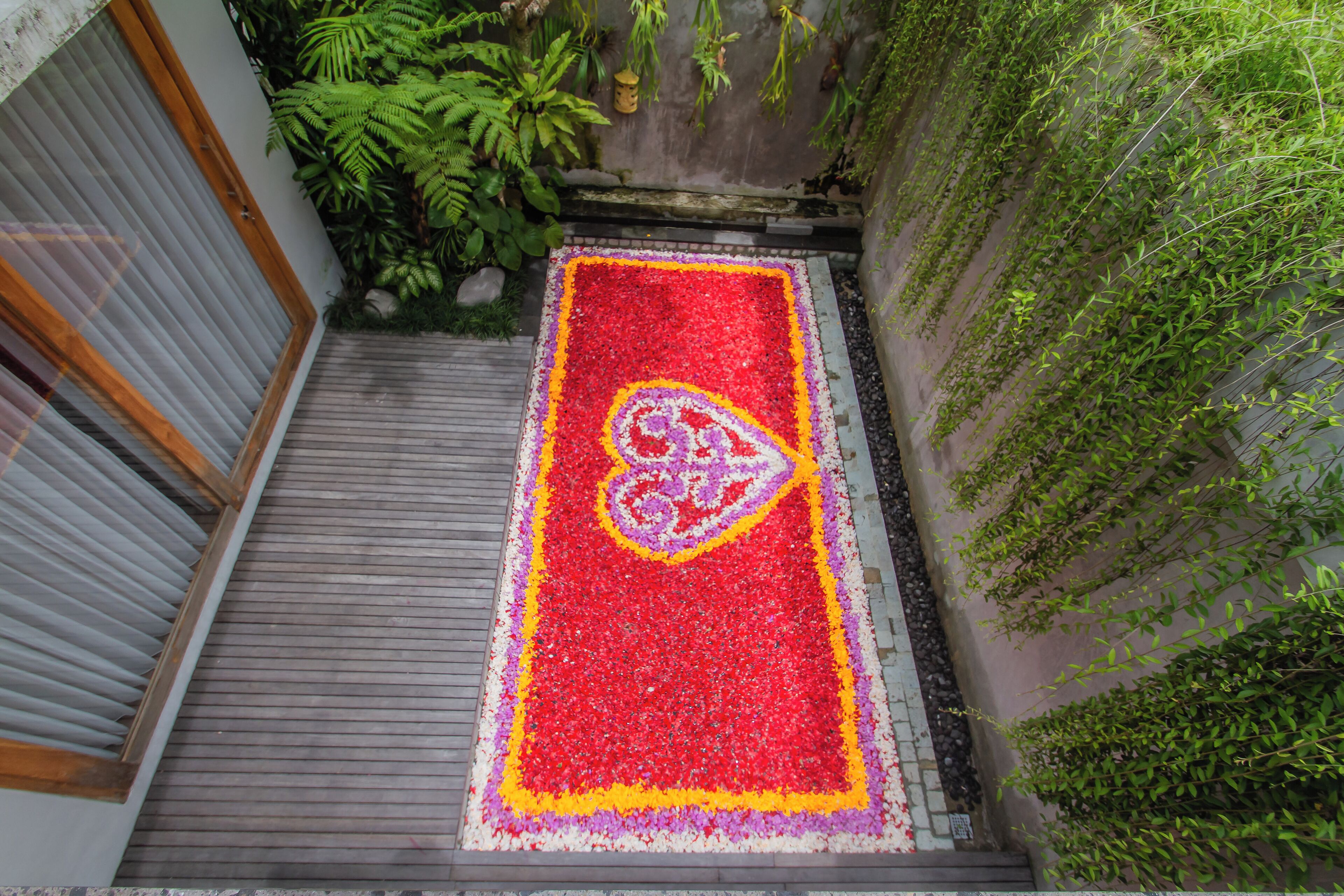Un étroit sentier, bordé d’une profusion de fleurs, mène à l’entrée d’un bâtiment.