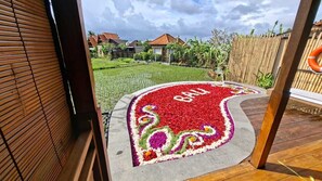 A garden with a red and white flower bed with the word "Bali" in the center. - DITUJU Ubud by GenuineHost (Sukawati)