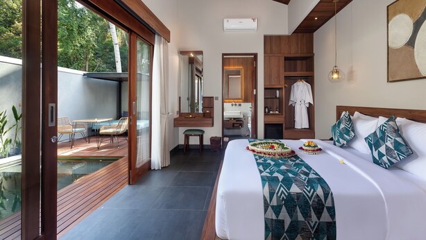 Une chambre moderne dotée d’un grand lit, d’une salle de bain et d’un coin repas offrant une vue sur l’extérieur.