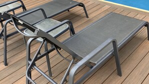 Un espace piscine avec des chaises longues et un jacuzzi.