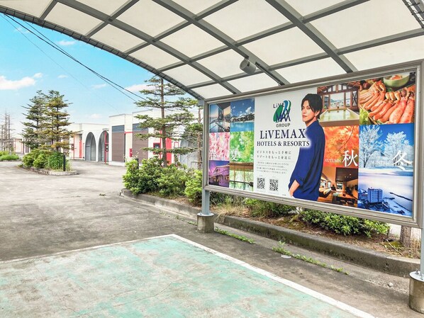 A billboard advertising LIVEMAX hotels and resorts with a QR code, featuring images of food and seasonal themes. - HOTEL LiVEMAX Kuroishi (Kuroishi)