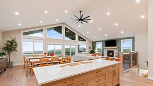 Una cocina amplia con una isla grande, armarios de madera y una chimenea.