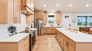 Una cocina moderna con armarios de madera, electrodomésticos de acero inoxidable y una isla grande.
