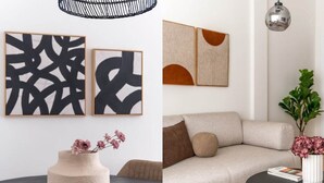 A modern living room with a sofa, a coffee table, and a vase with flowers. There are abstract paintings on the wall. - Modern Athenian Nest near Kallimarmaro Stadium (Athina)