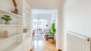 A hallway with white shelving, a potted plant, and a radiator. - Modern Athenian Nest near Kallimarmaro Stadium (Athina)