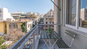 A balcony with a view of a cityscape, a bench, and a railing. - Modern Athenian Nest near Kallimarmaro Stadium (Athina)