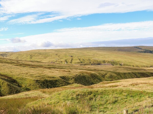 A hilly landscape with a small building in the distance. - The Museum (Alston)
