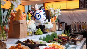 Un tavolo da buffet con diversi piatti e una statuina decorativa a forma di chef.