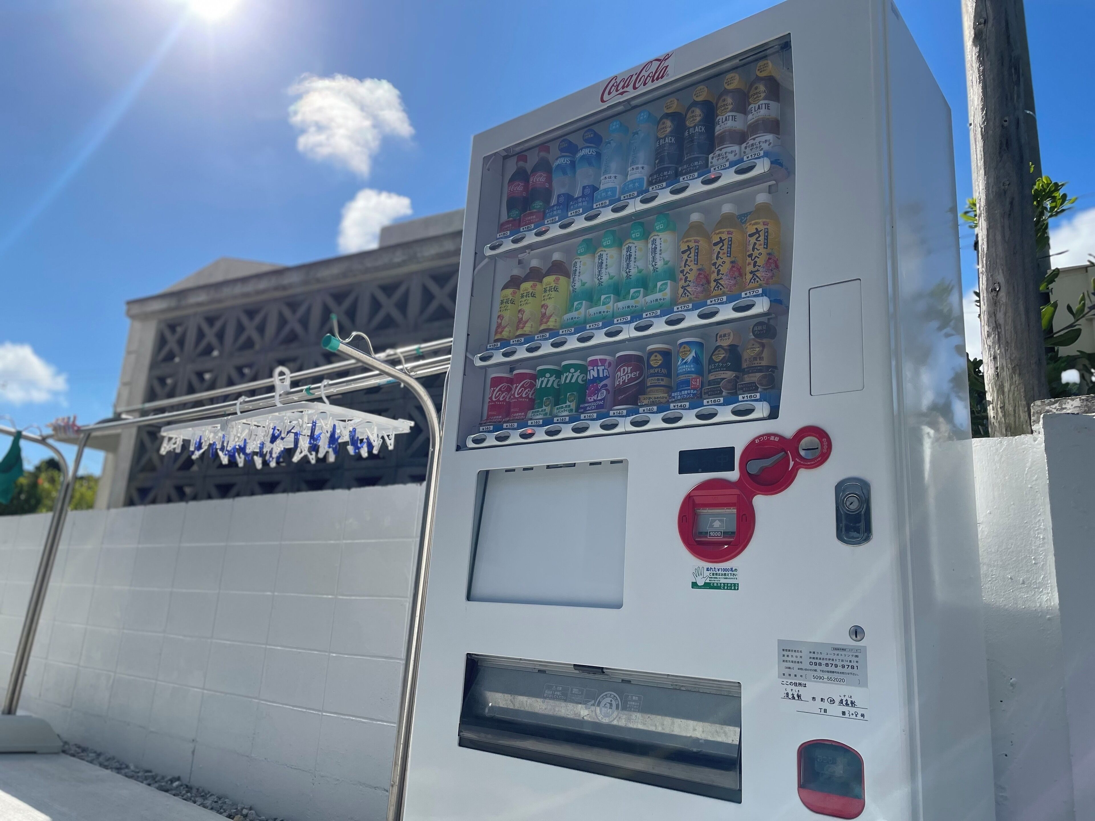 Máquina expendedora con diversas bebidas y aperitivos, ranura para monedas y terminal de pago.