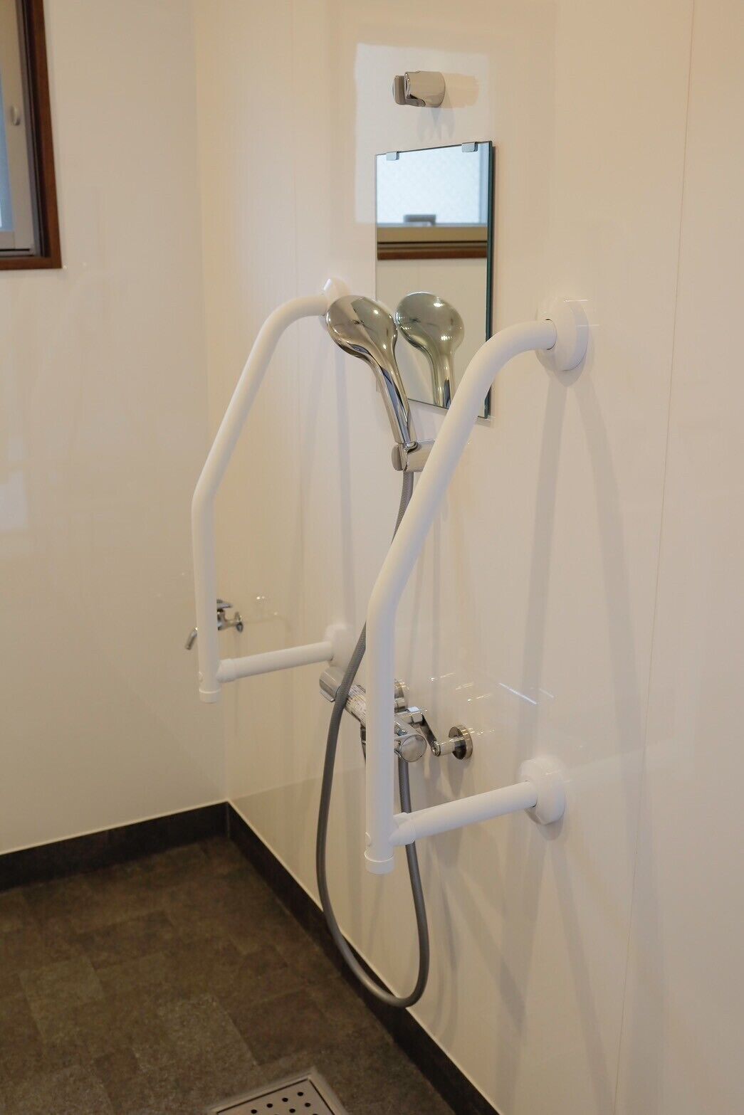 Een douche met een handdouche en een apart handmatige douche.