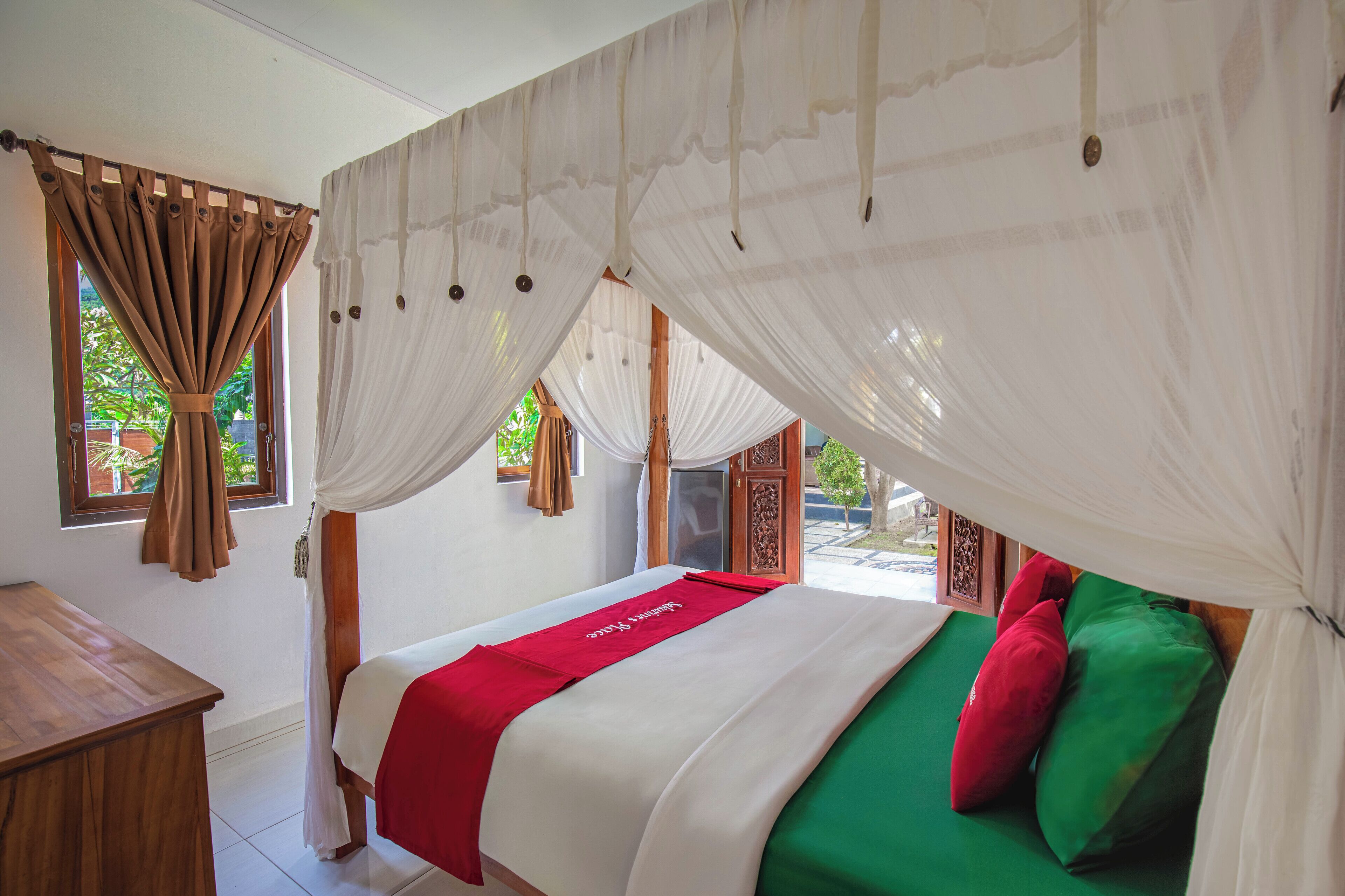 Un dormitorio con una cama, una mesita de noche de madera y una ventana con cortinas.