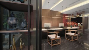 A modern hotel lobby with a reception desk, seating area, and decorative items including a horse statue and traditional vases. - chengduchengguojiudian (Chengdu)