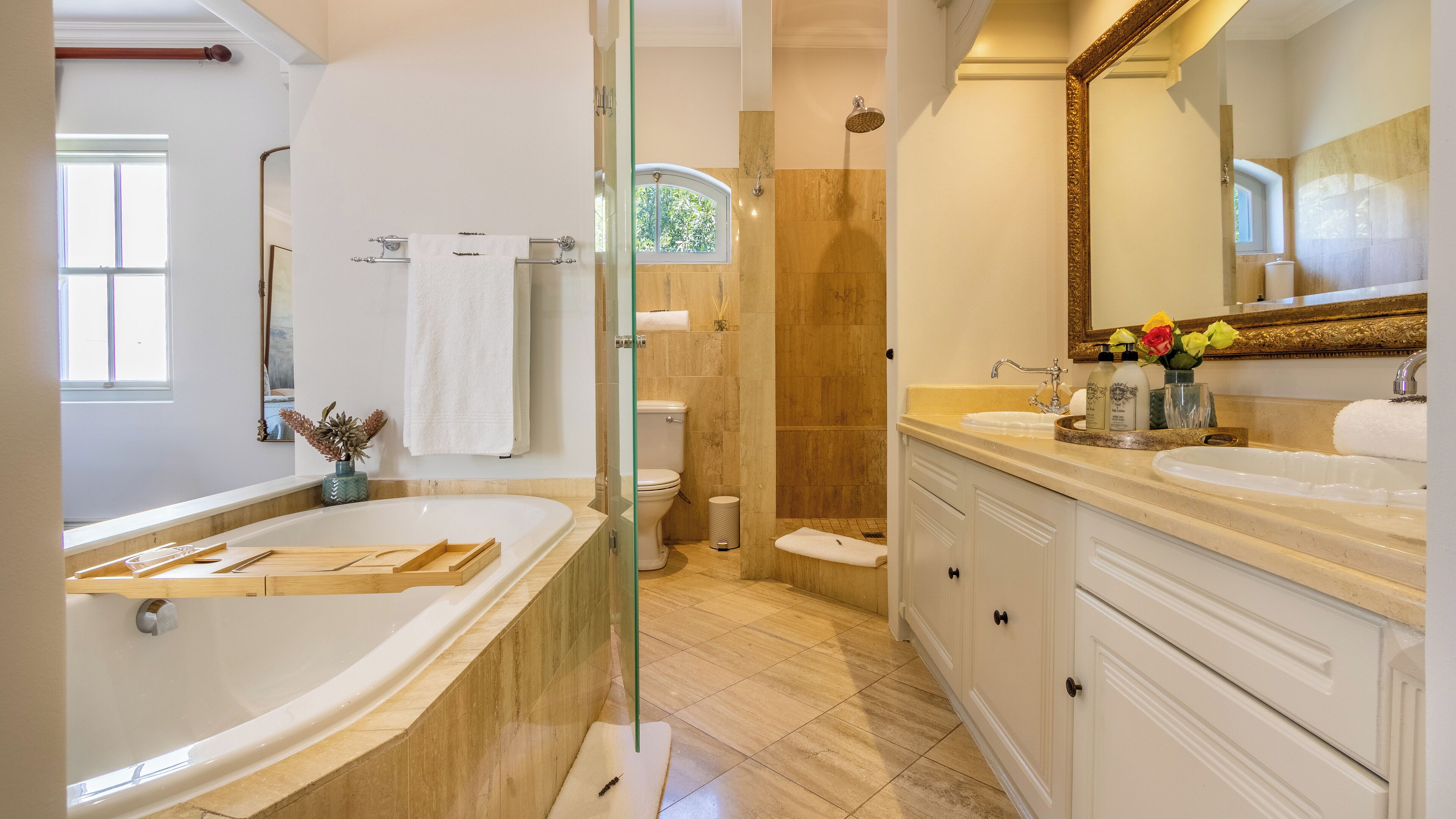 A modern bathroom with a freestanding bathtub, a glass-enclosed shower, and a vanity with a large mirror.