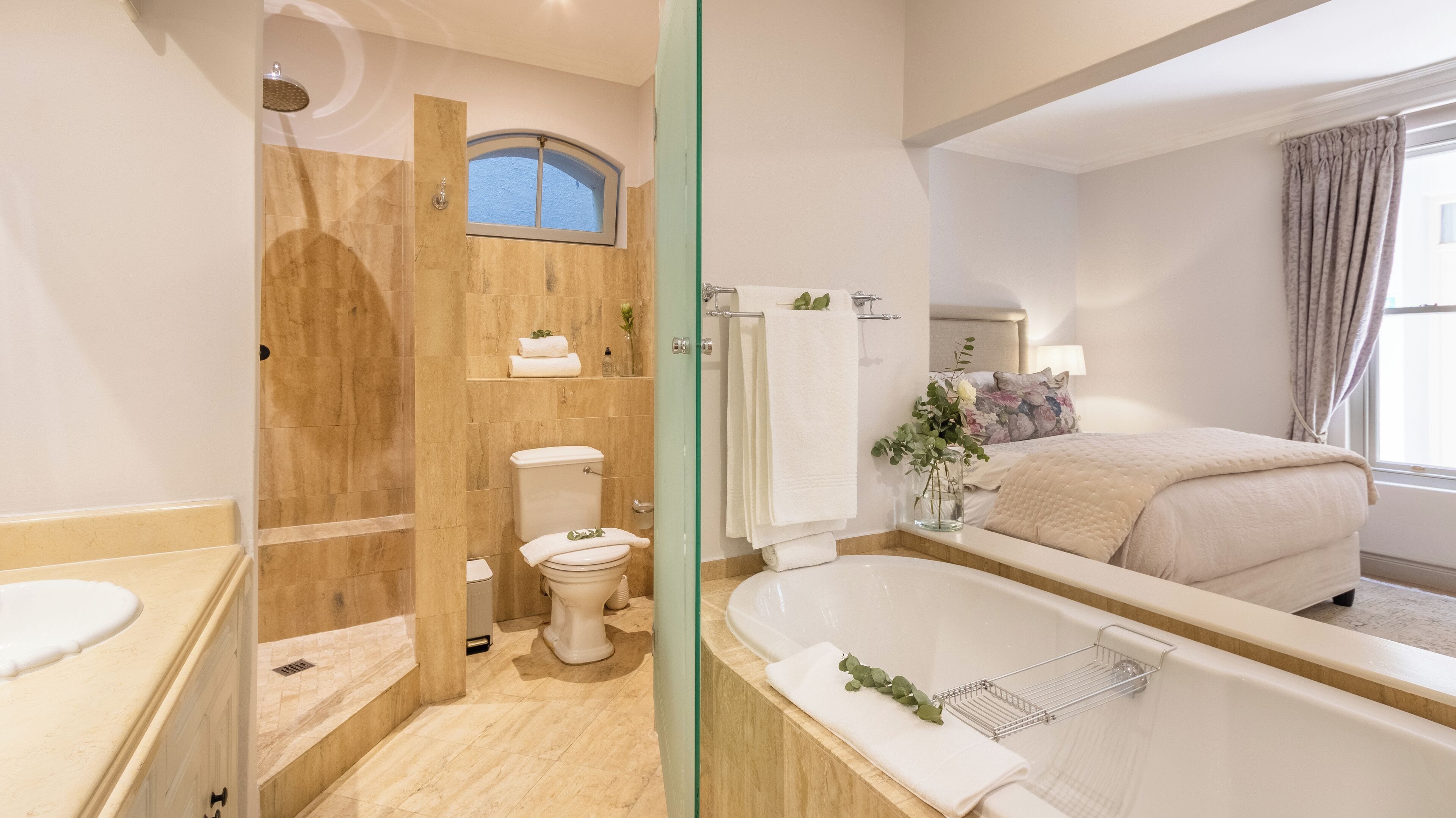 A modern bathroom with a bathtub, toilet, and shower.