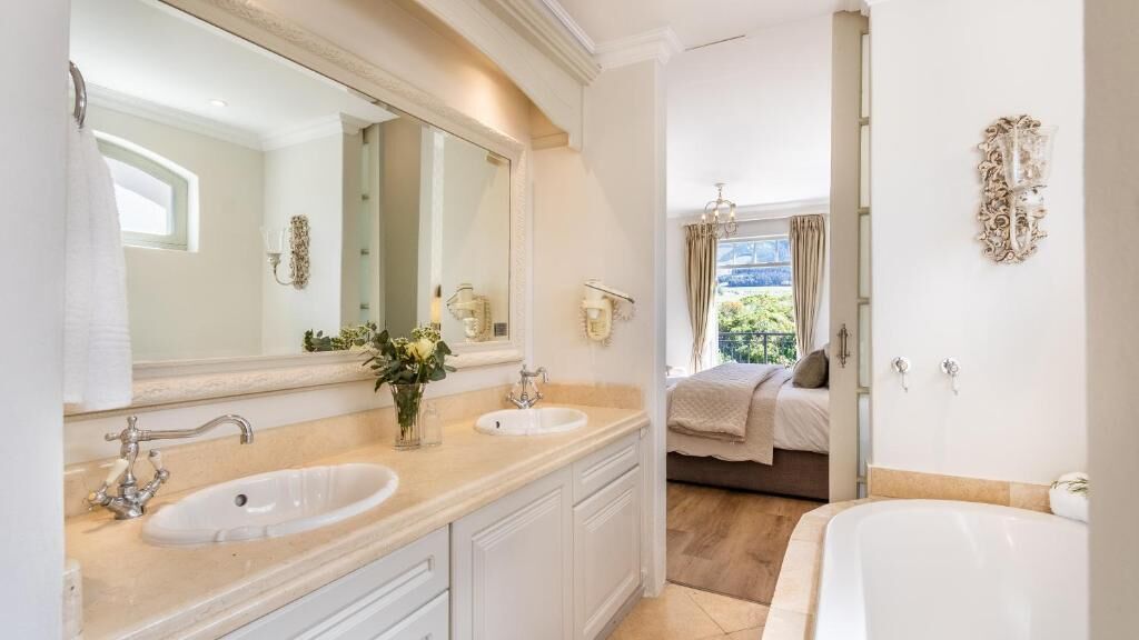 A bathroom with two sinks, a large mirror, and a bathtub.