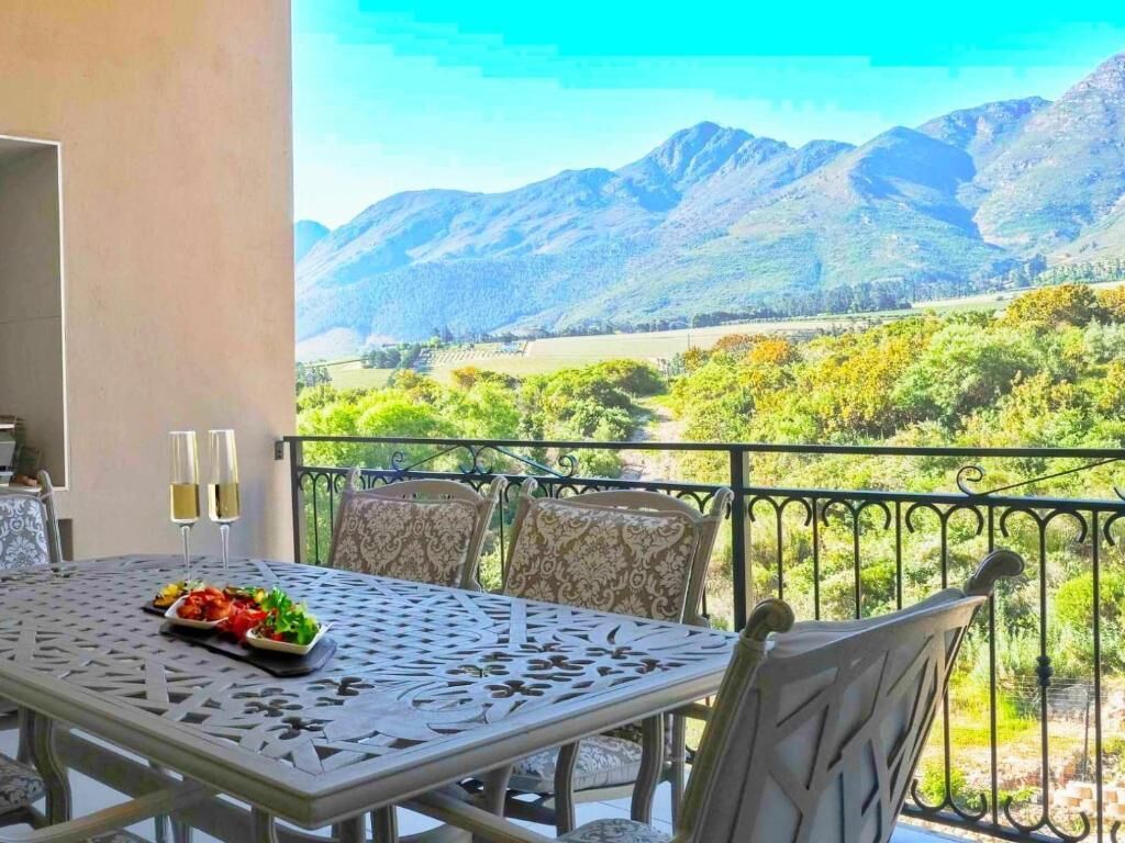 A dining table with chairs and a view of mountains.