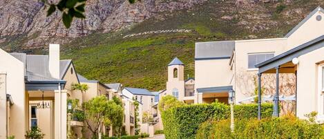 A residential street with houses, a church, and a mountain in the background.
