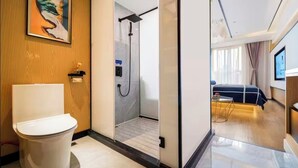 A modern bathroom with a toilet, shower, and a bed in the adjacent room. - Z Holiday Hotel (Chengdu)
