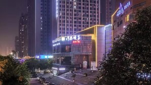 A high-rise hotel with illuminated signage, a prominent entrance, and a surrounding urban environment. - Z Holiday Hotel (Chengdu)
