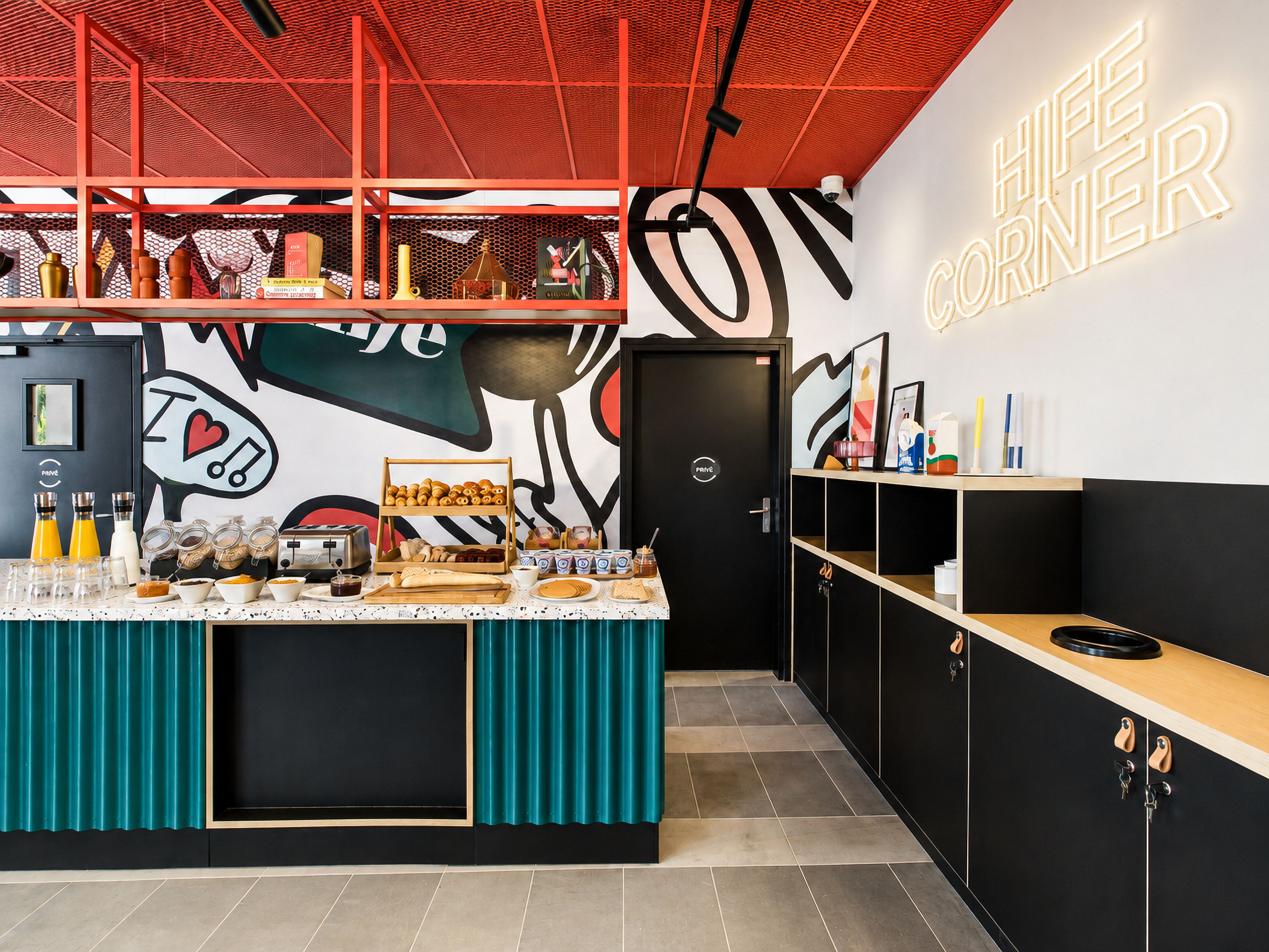 A modern kitchen area with a breakfast bar, a neon sign, and various kitchen appliances.