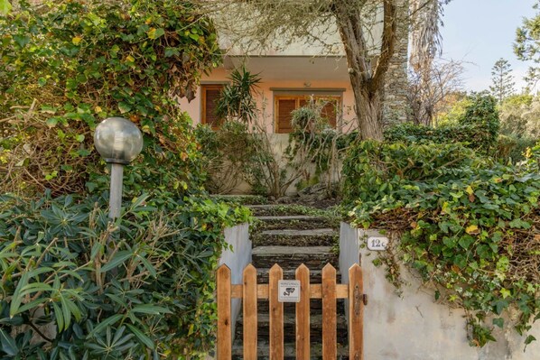 Un immeuble résidentiel doté d’un portail en bois, d’un lampadaire en métal et d’une plaque indiquant le numéro de l’immeuble.