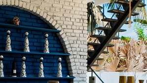 A bar area with a brick wall, blue shelves, and a staircase. - Coastal Retreat Mirissa (Mirissa)