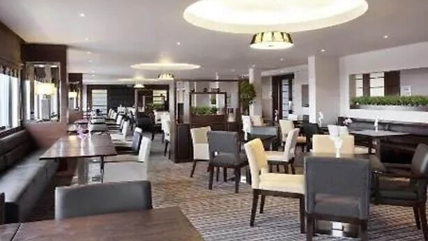 Un restaurant moderne doté d’un long comptoir, de nombreuses tables et de chaises.