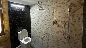 A bathroom with a toilet, a shower, and a sink. - Desire Courtyard (New Delhi)